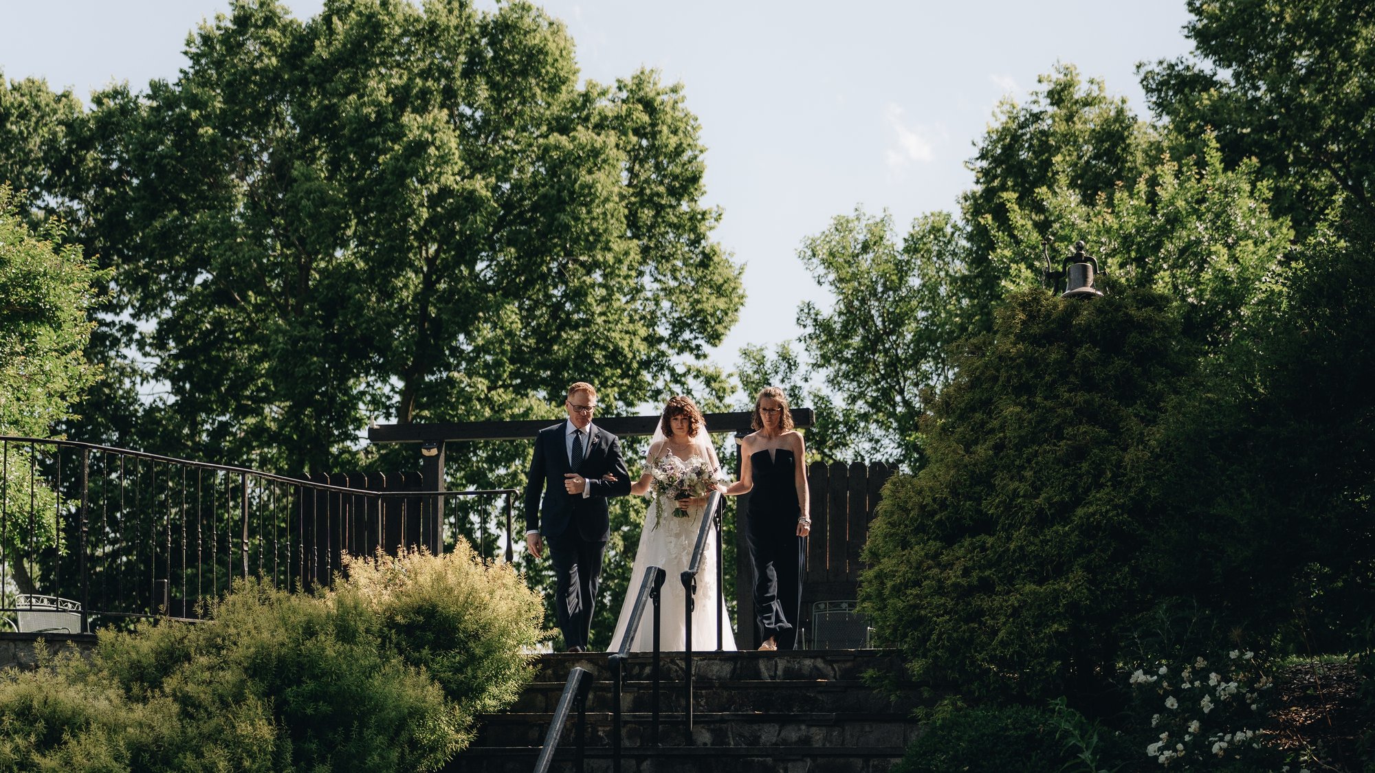 The ceremony from above, guests seated on the grass and the couple at the front with the river behind them