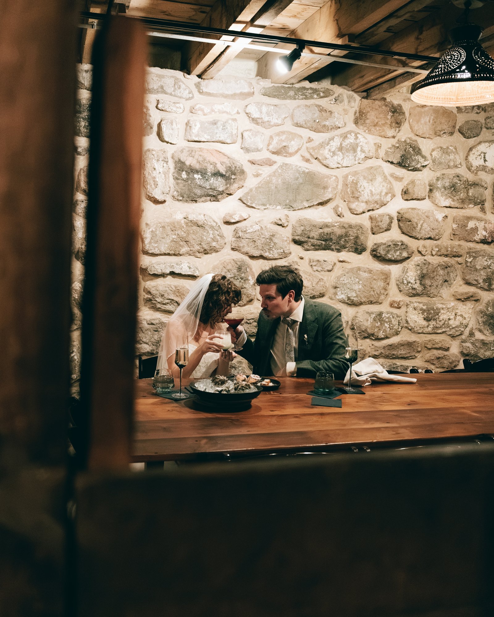 The bride and groom eating together alone in a stone walled room