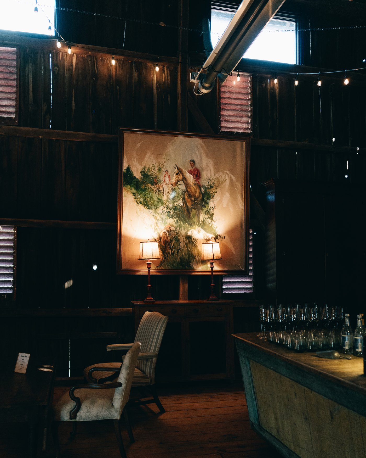 The bar in the barn, bottles lit by lamplight