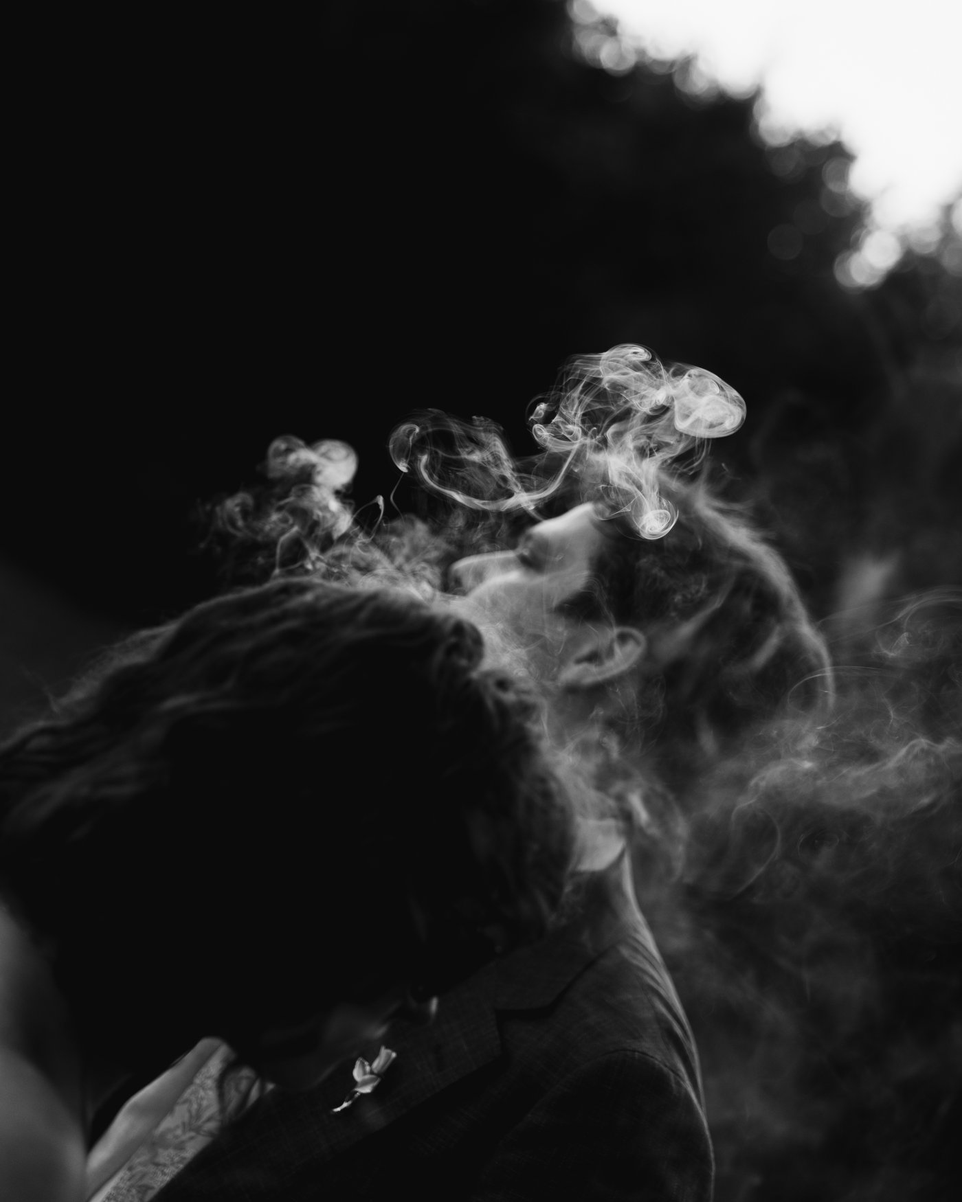 Black and white, cigar smoke curling through the dark