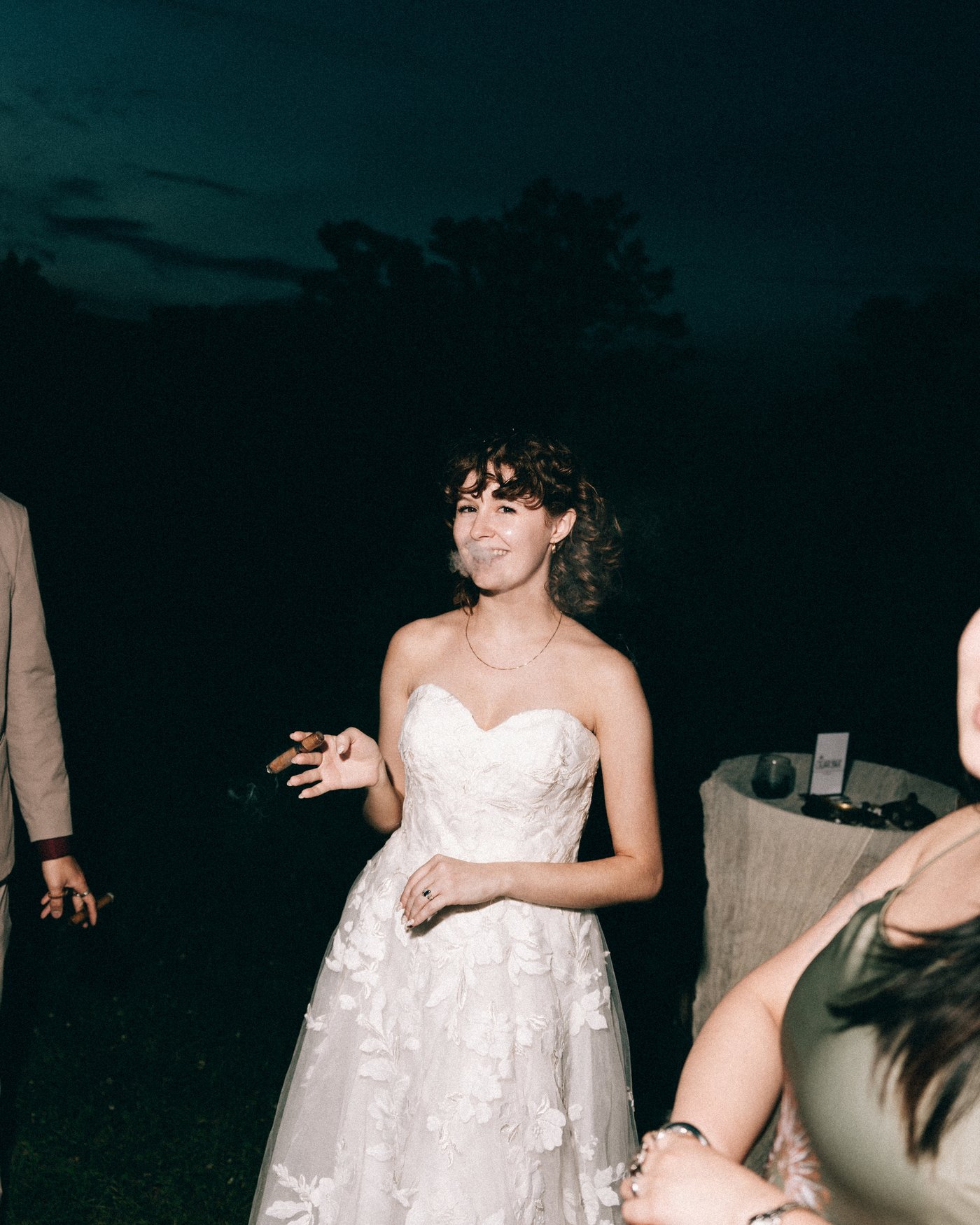 The bride laughing among the guests late in the night