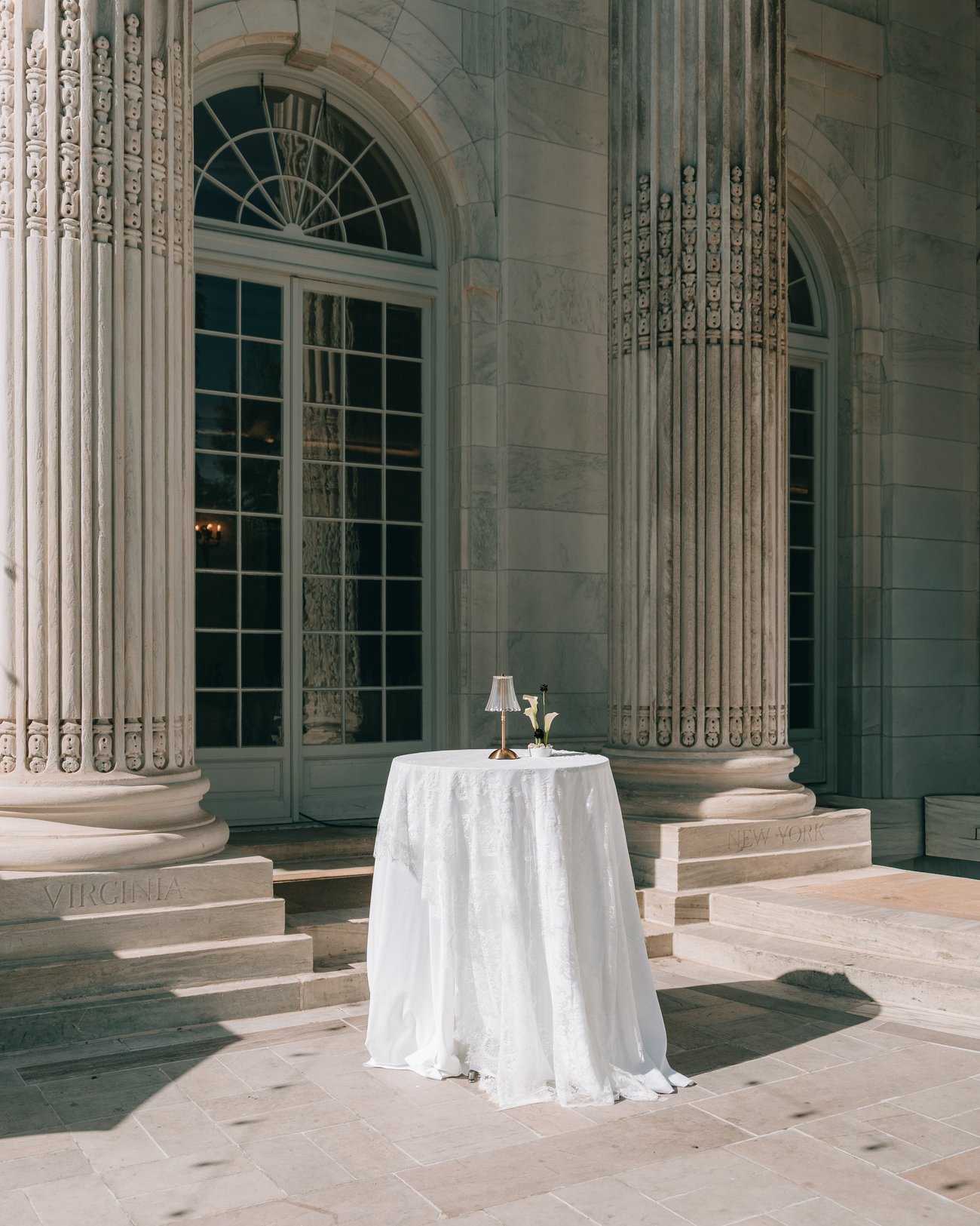 One cloth covered table standing alone on a stone terrace between fluted columns