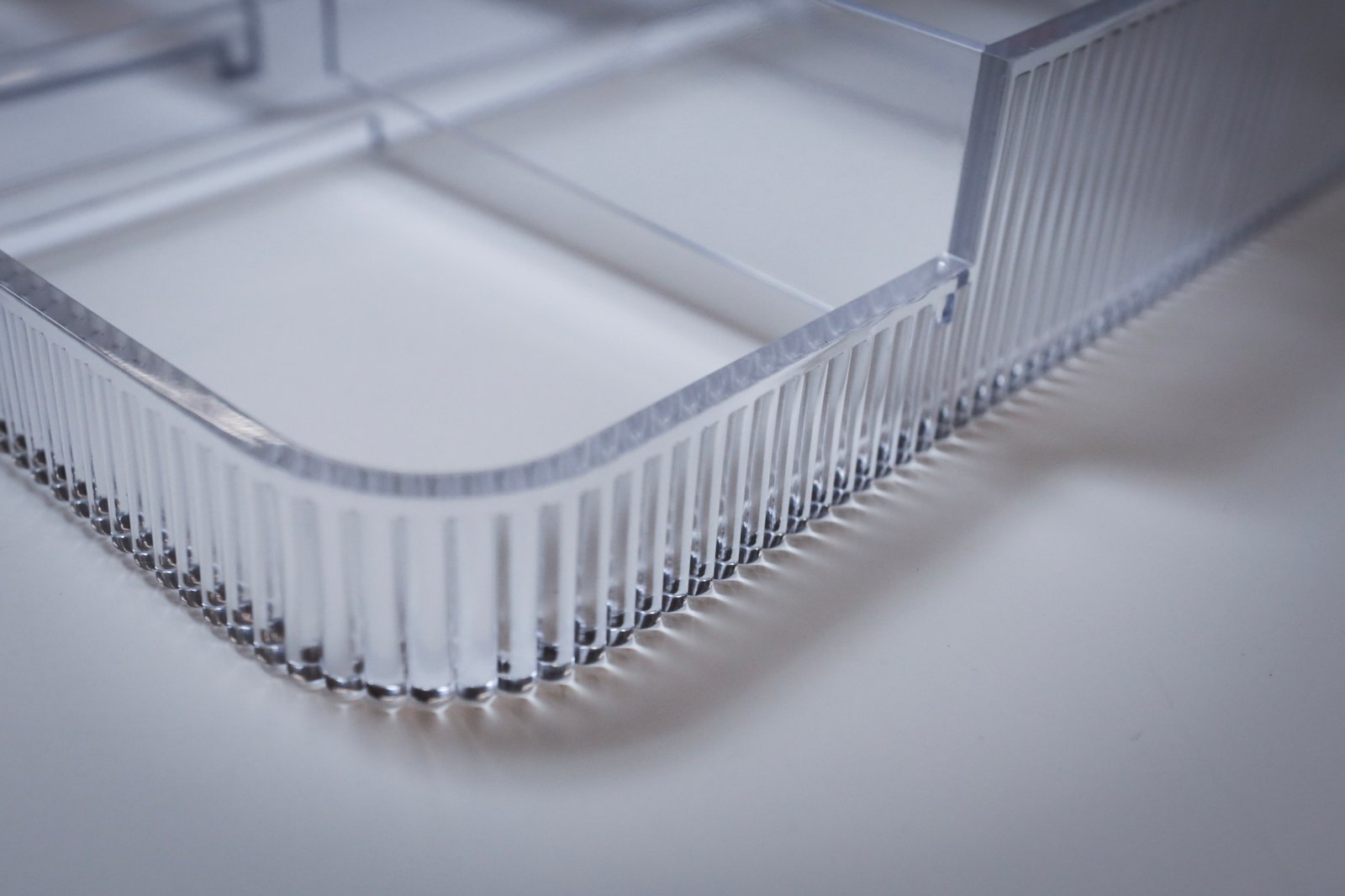 Fine fluted detail on an optical clear wall. Surface quality at this scale decides whether light transmits or scatters.