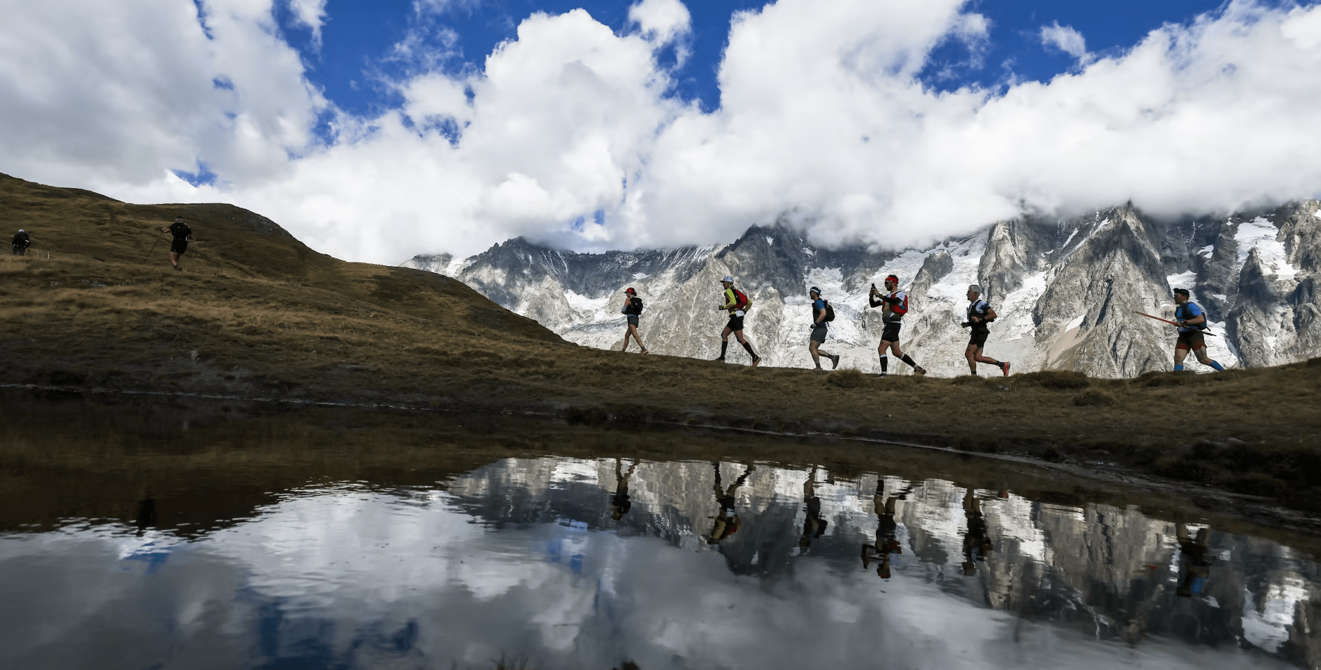 Runner taking a selfie next to a mountain lake with a Garmin watch