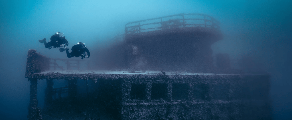 two divers exploring sunken shipwreck with garmin