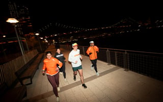 Group of runners at night wearing STRAVA running shirts