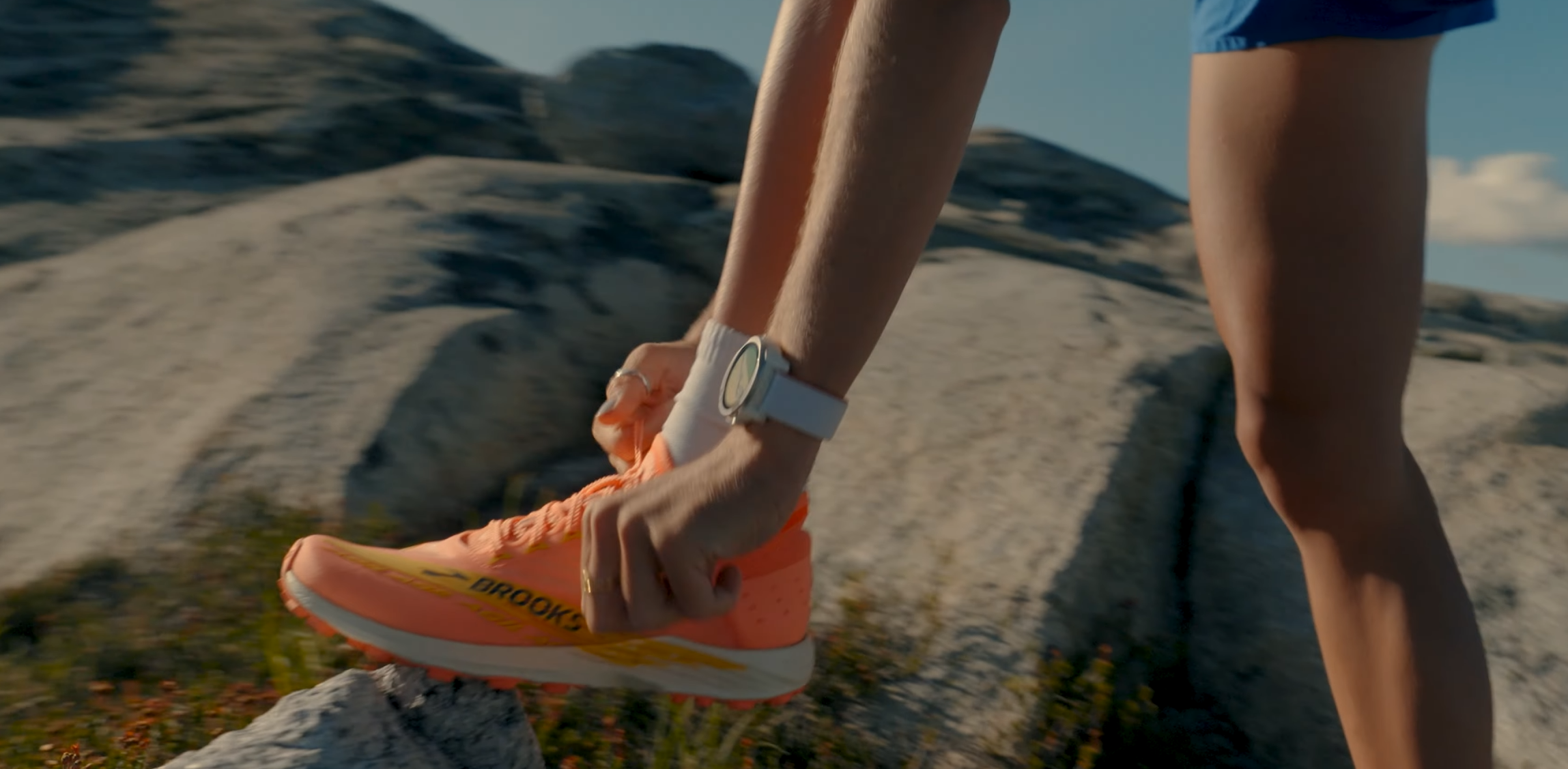 coros apex 4 : mountain runners ties her running shoes wearing watch