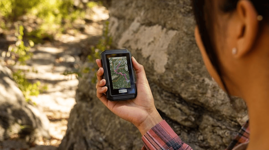 woman holding Garmin eTrex Touch looking at route on outdoors map+