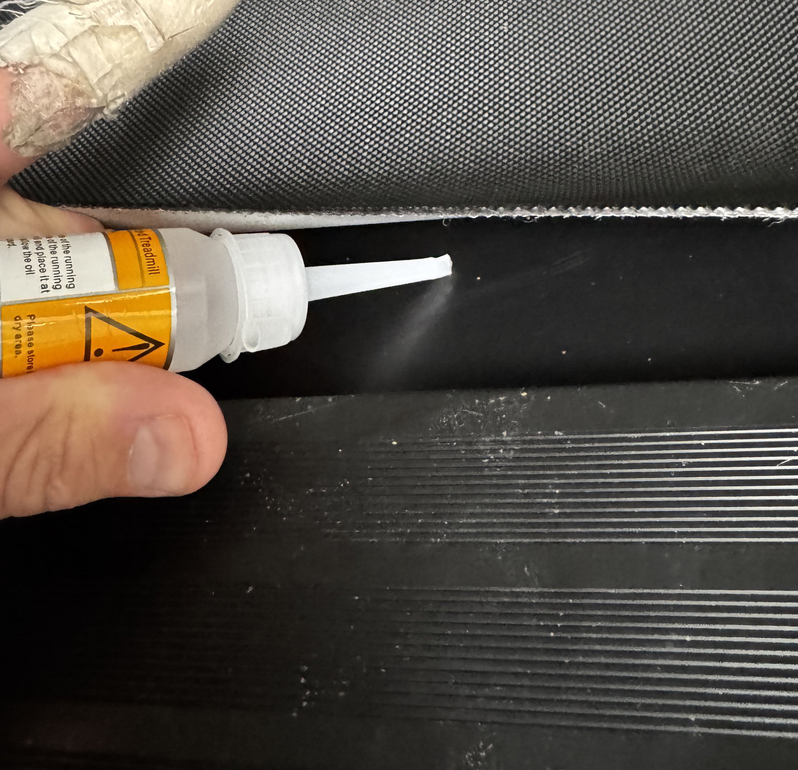 Applying maintenance oil to the THERUN T15 treadmill belt