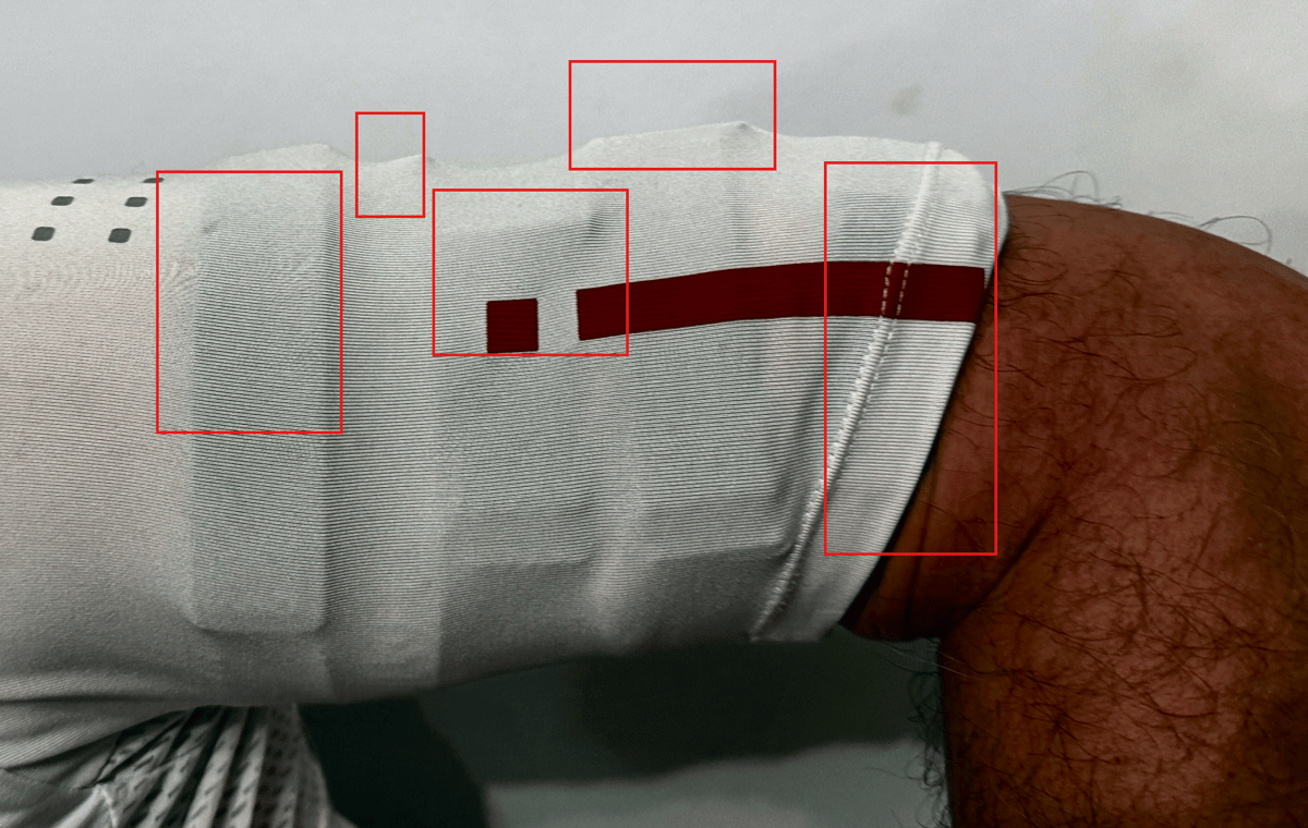 Five optical heart rate monitors worn under cycling jersey sleeve during product testing comparison