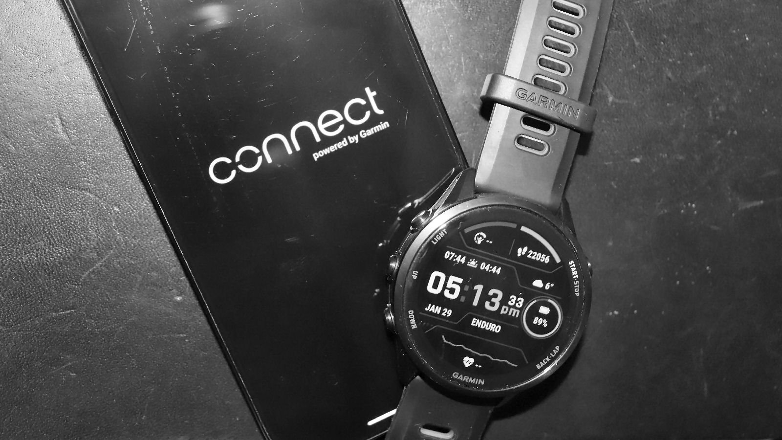 Garmin Forerunner 970 beside iPhone showing Garmin Connect app disconnected status