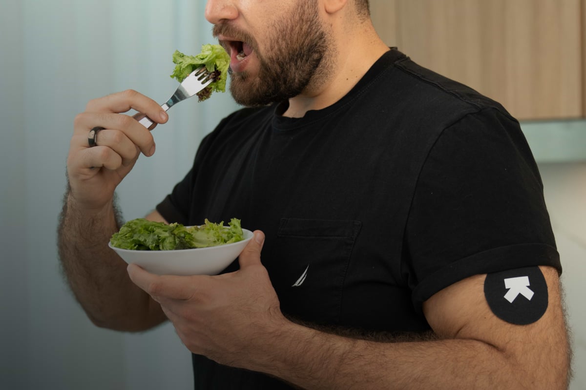 Ultrahuman M1 continuous glucose monitor worn on arm, used in sleep consistency and blood glucose variability study