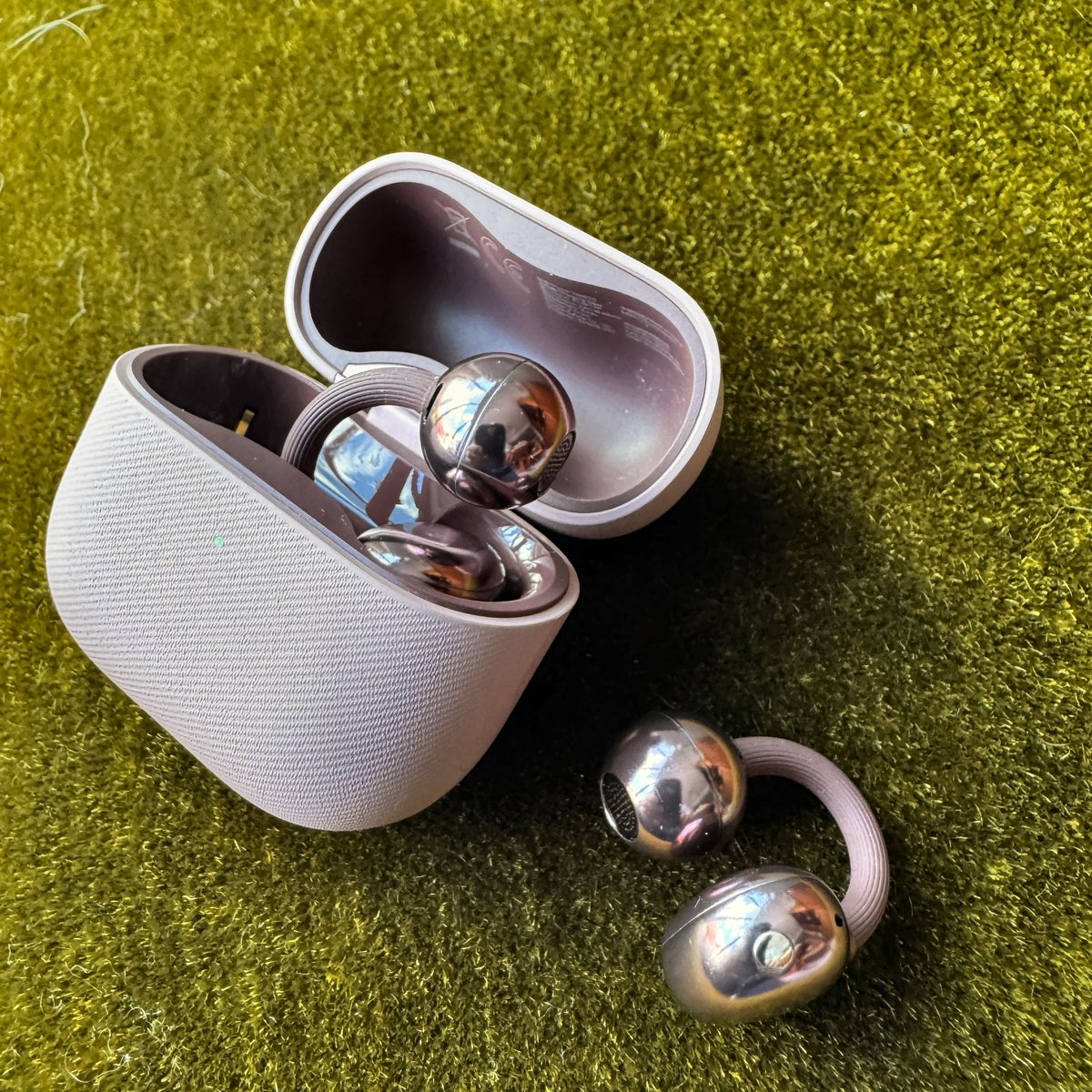Huawei FreeClip 2 open-ear earbuds showing the clip-on C-bridge design that fits around the outer ear and the charging case