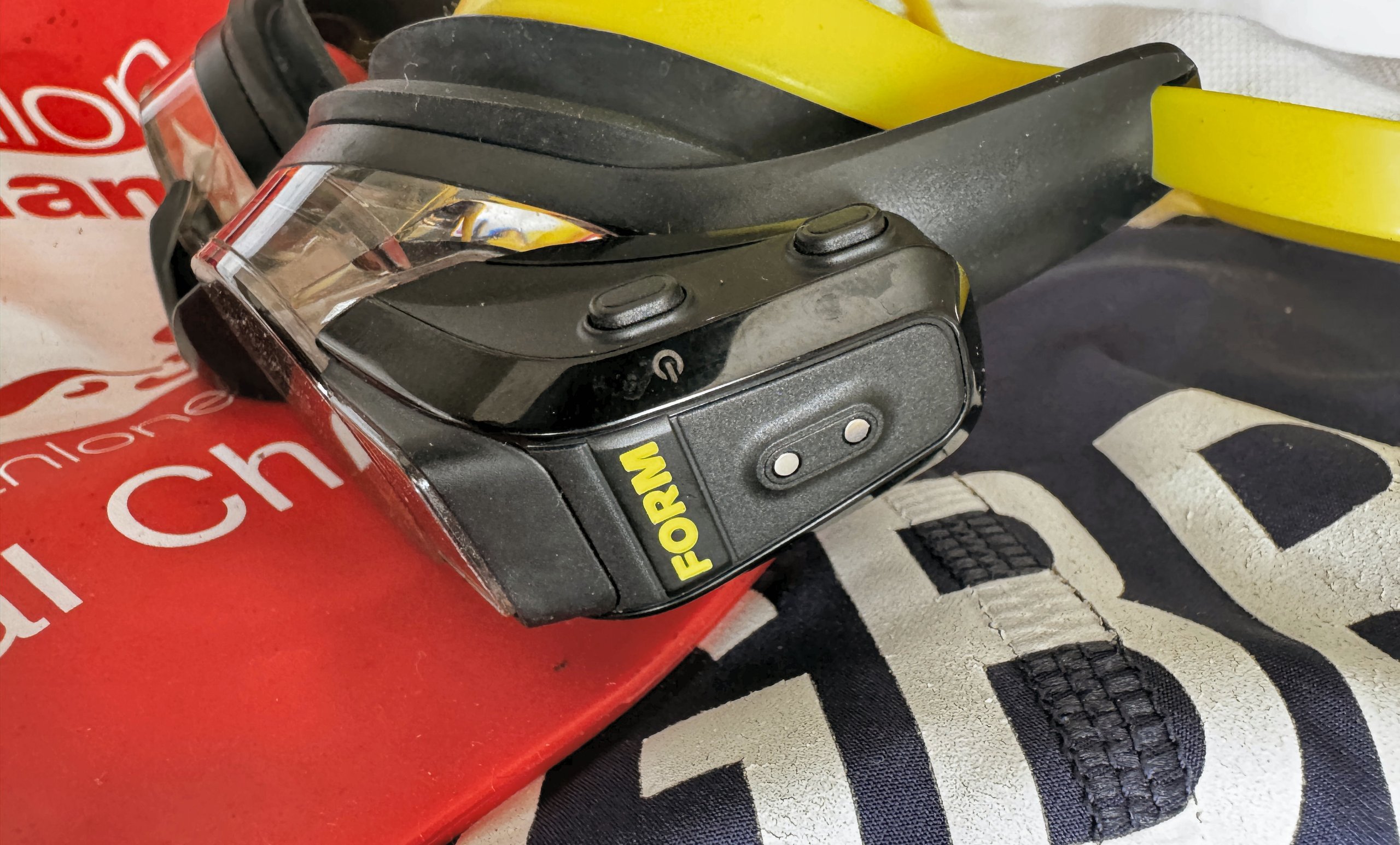 FORM Smart Swim 2 LT close-up showing two control buttons and USB charging point on temple pod