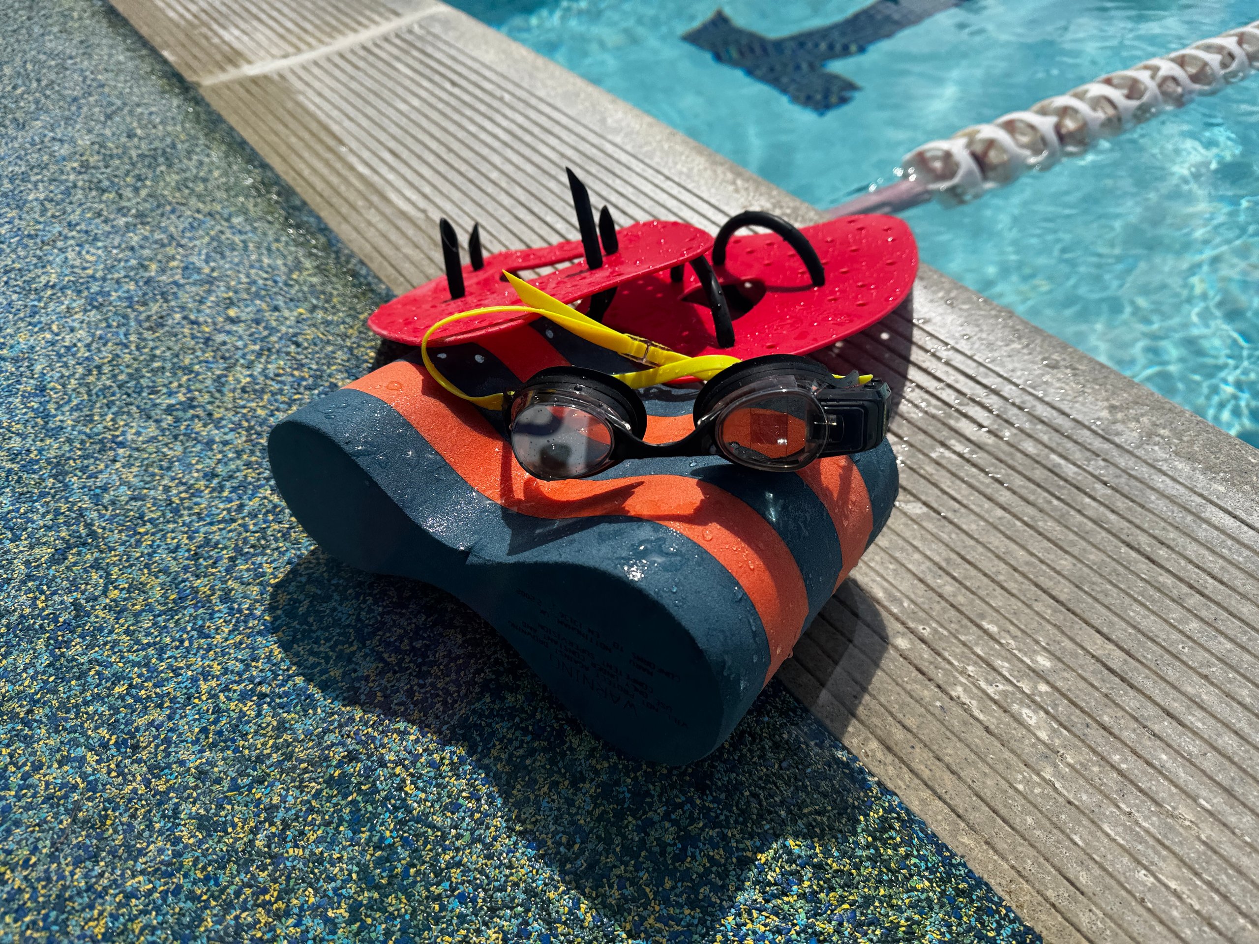 FORM Smart Swim 2 LT goggles on poolside showing AR display pod and lens
