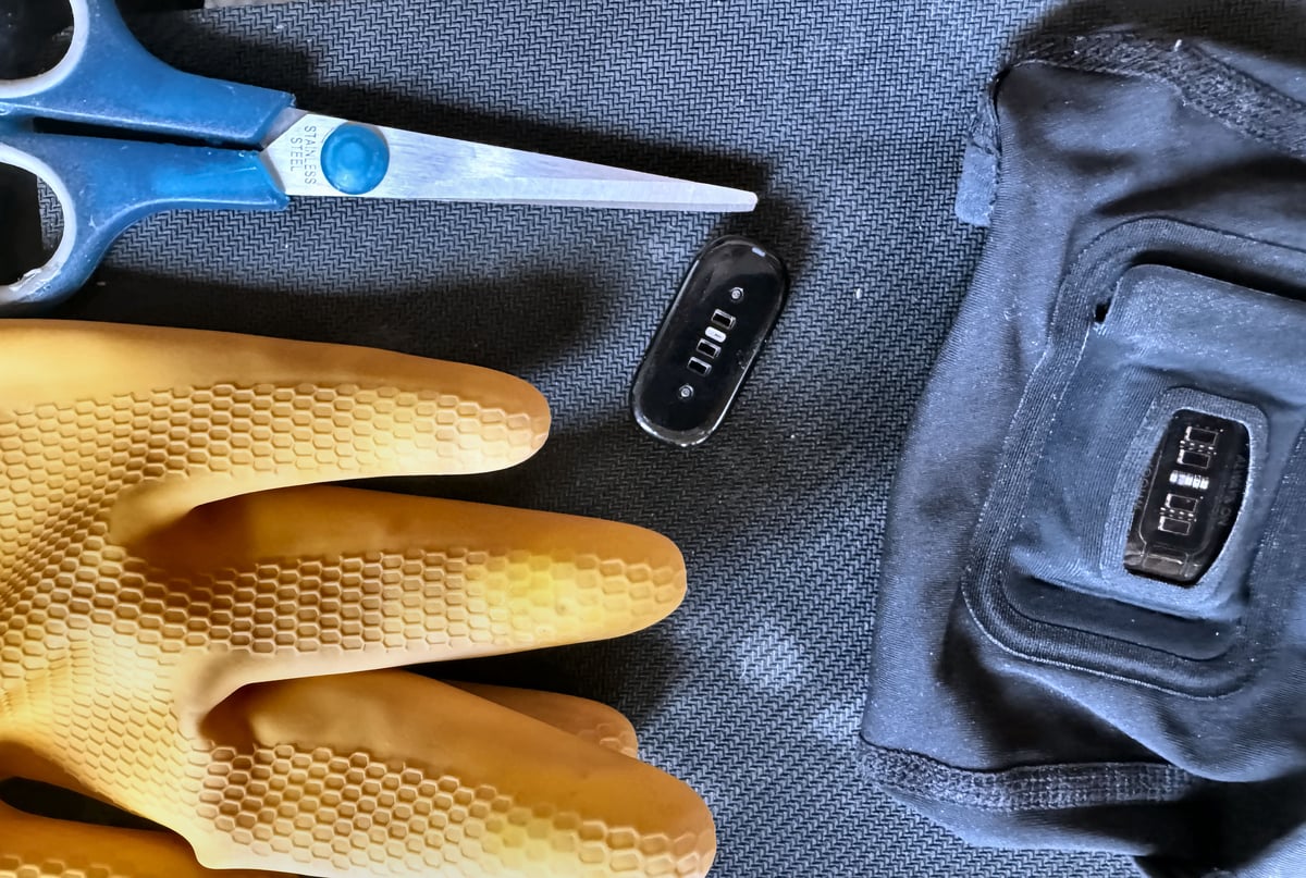 Fitbit Air pebble inside Whoop Any-Wear arm sleeve pod with rubber washing-up glove shims