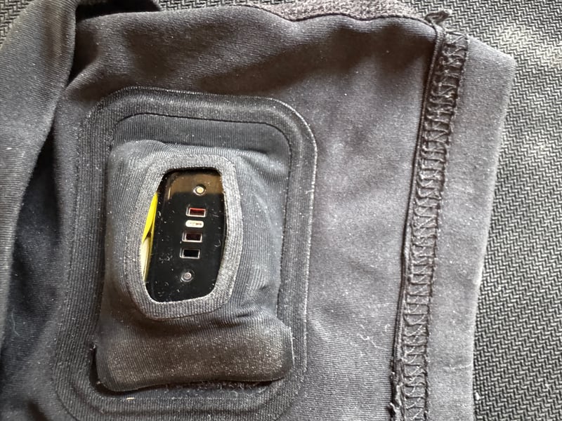 Fitbit Air pebble centralised in Whoop Any-Wear arm sleeve pod with rubber washing-up glove shims