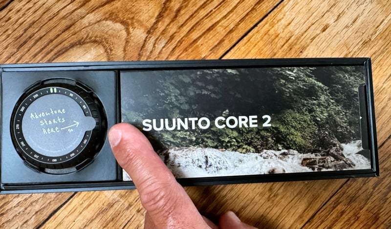 Suunto Core 2 All Black outdoor watch on wrist, front view showing dot-matrix display and stainless steel bezel