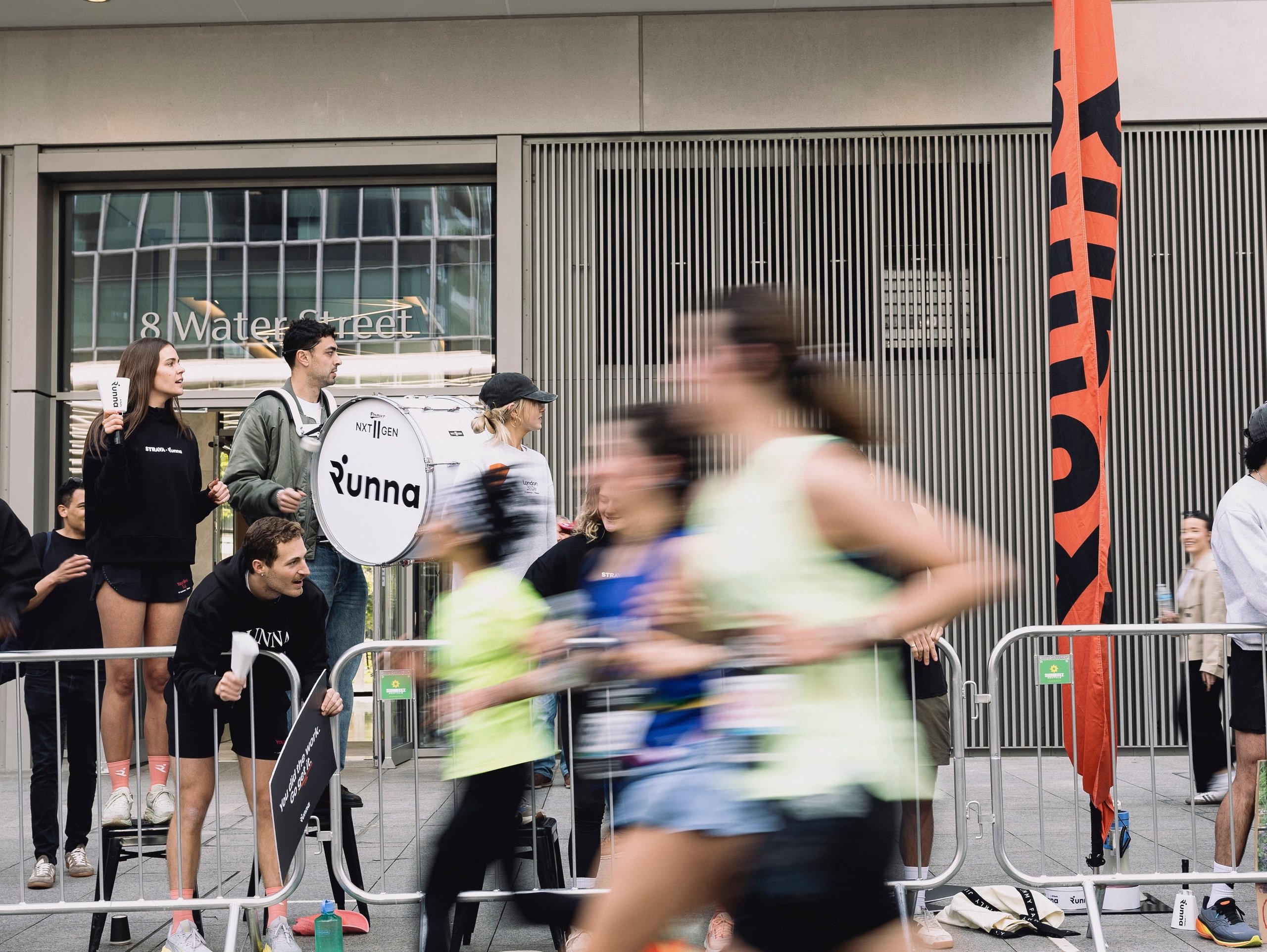 woman running in London_Marathon_Race_Day_2026_runna past a crowd holding a runna banner