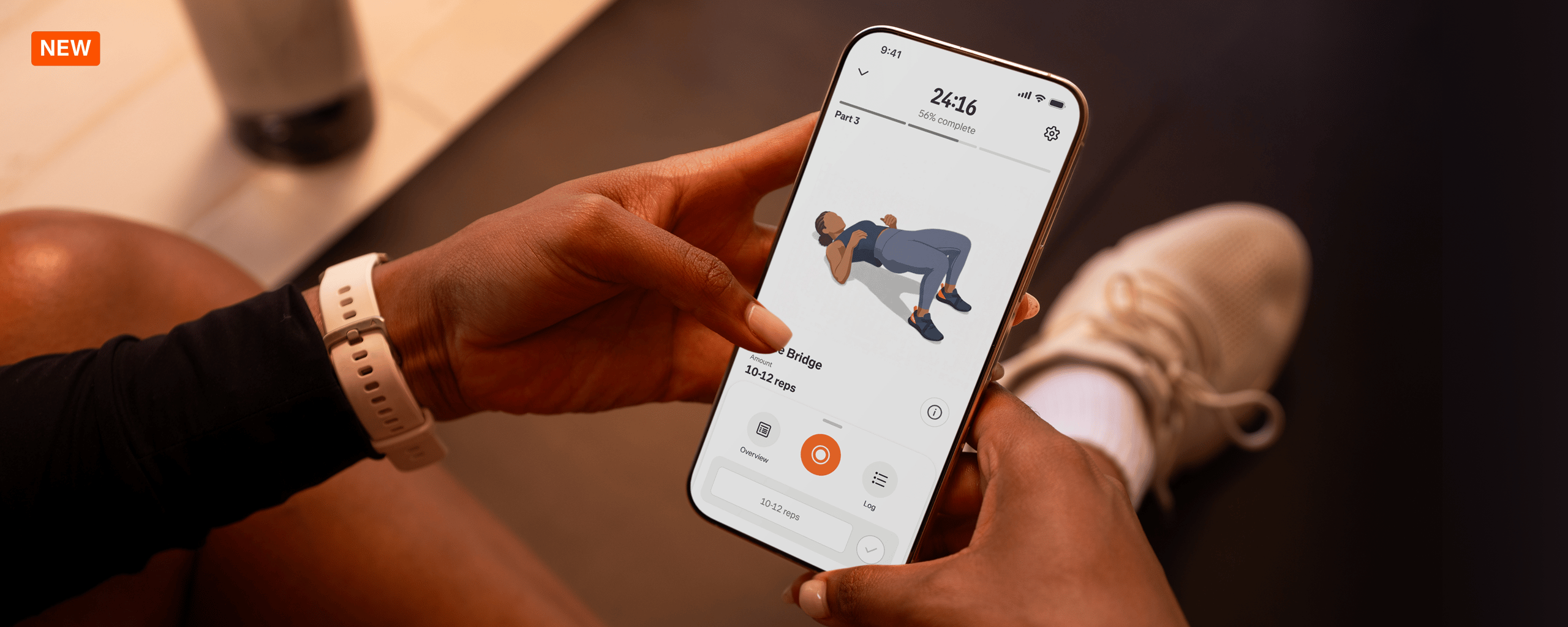 Athlete holding a smartphone showing a Strava guided strength workout exercise animation