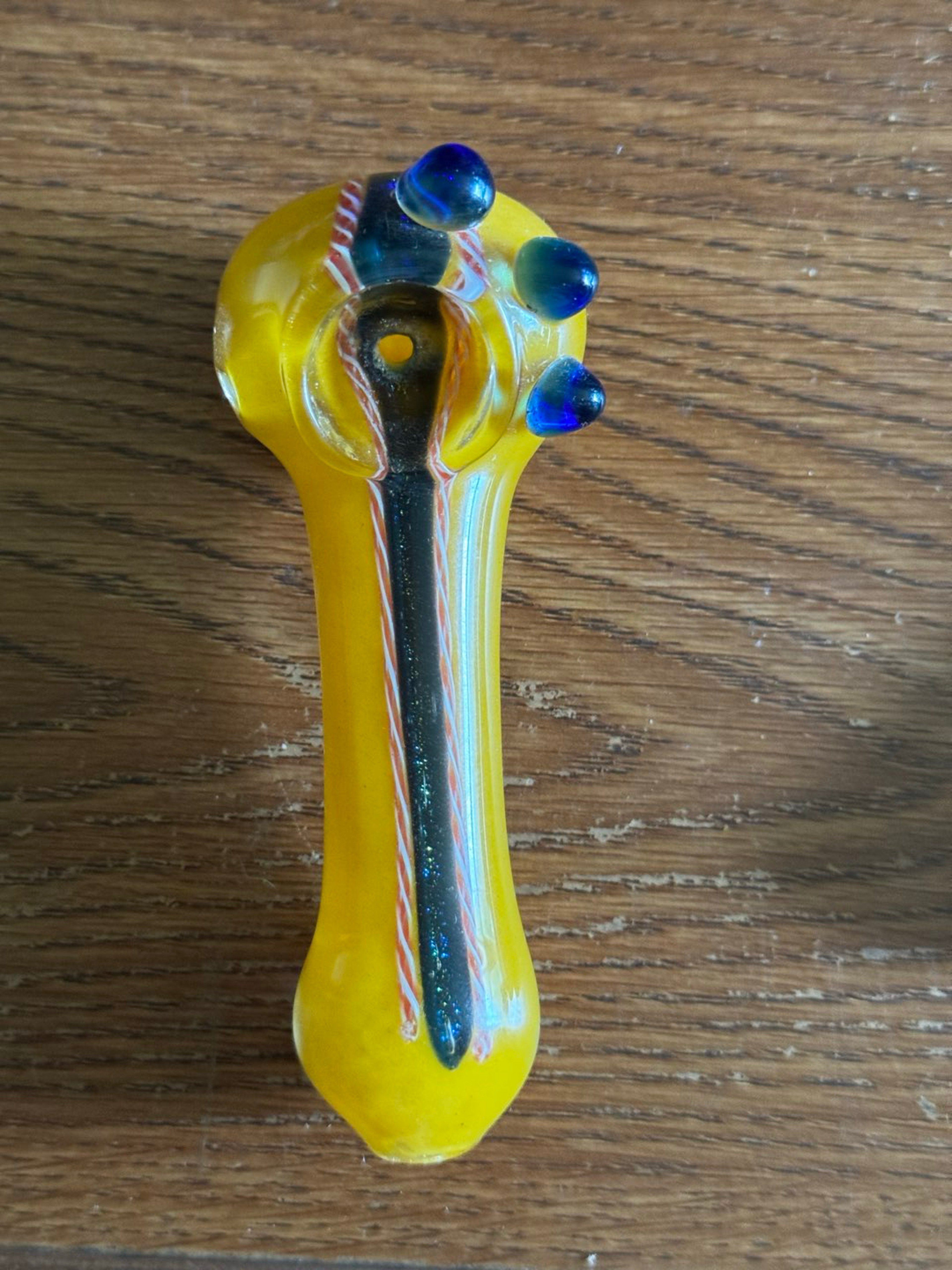 Preview pic of Bright yellow spoon with blue marble accents + black/orange cane work