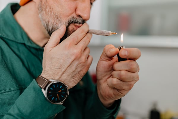 A close-up of a mature Caucasian man taking a hit of medical marijuana.