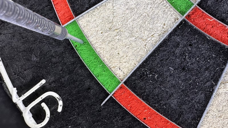 A dart landing in the double 16 segment on a dartboard