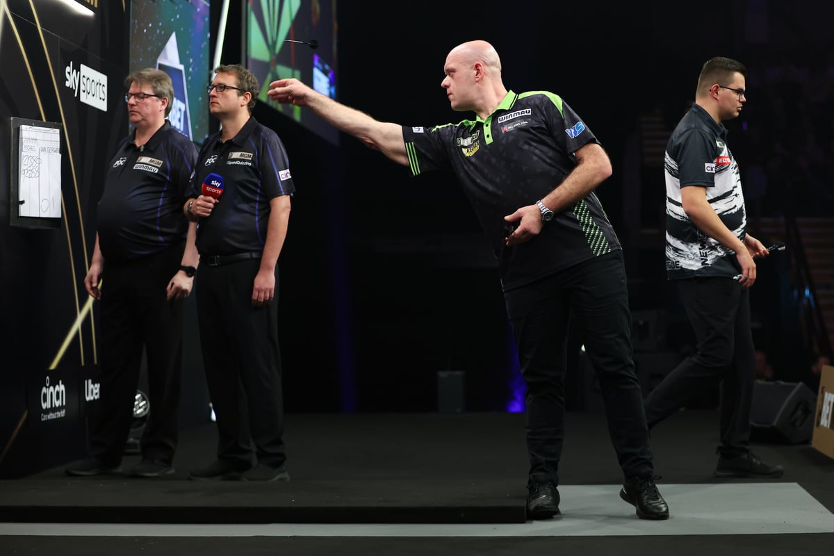 Michael van Gerwen mid-throw with arm extended towards the dartboard