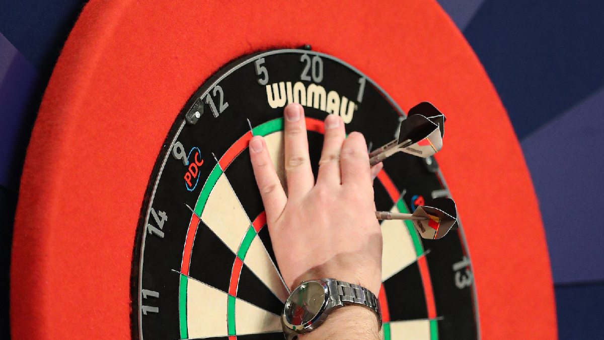 Three darts grouped tightly in the treble 20 bed on a professional dartboard