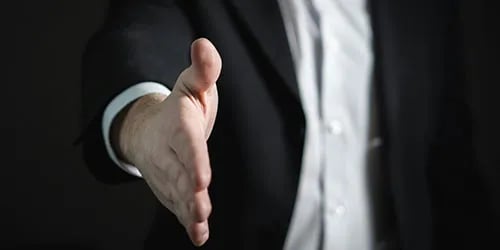 Closeup of a white business man holding out his hand to shake hands. 
