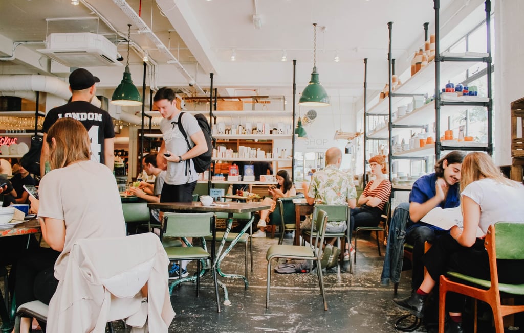 Jonge medewerkers in een informele setting van een kantine; nieuwe werkverbanden.
