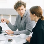 Werkgever en werknemer bespreken aan tafel een document over de re-integratie