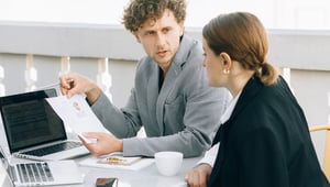 Werkgever en werknemer bespreken aan tafel een document over de re-integratie
