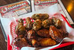 6 Mother Clucking Wings - Six crispy, juicy jumbo wings tossed in your favorite signature sauce or seasoned with one of our bold dry rubs. Served with one sauce. $8.95 (2 sets of 6 wings shown in photo)