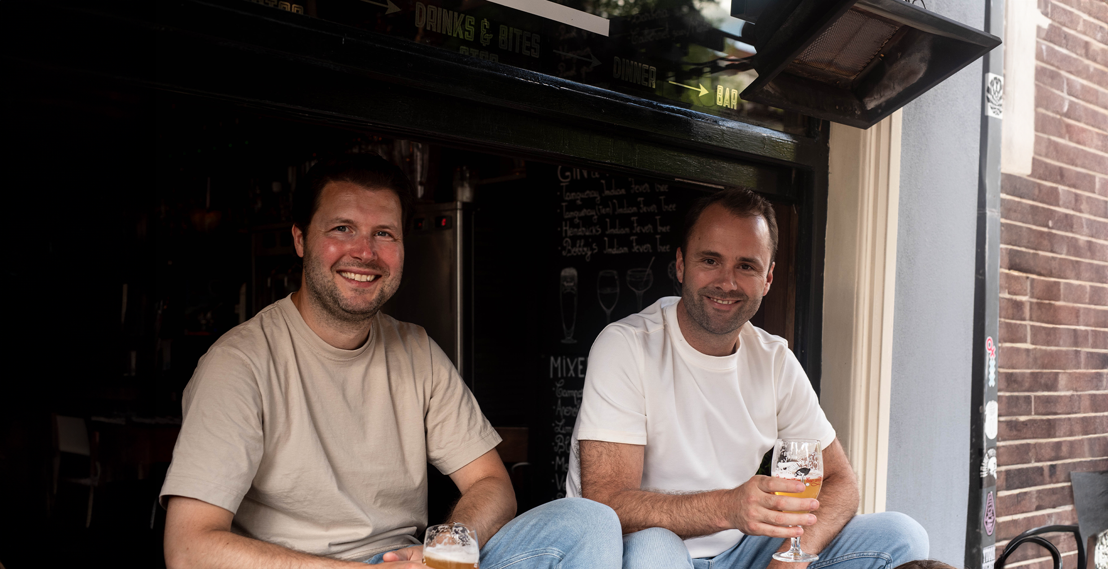 Collega’s genieten van drankjes terwijl bedrukte speelkaarten en gepersonaliseerde polaroids de borrel extra persoonlijk maken.