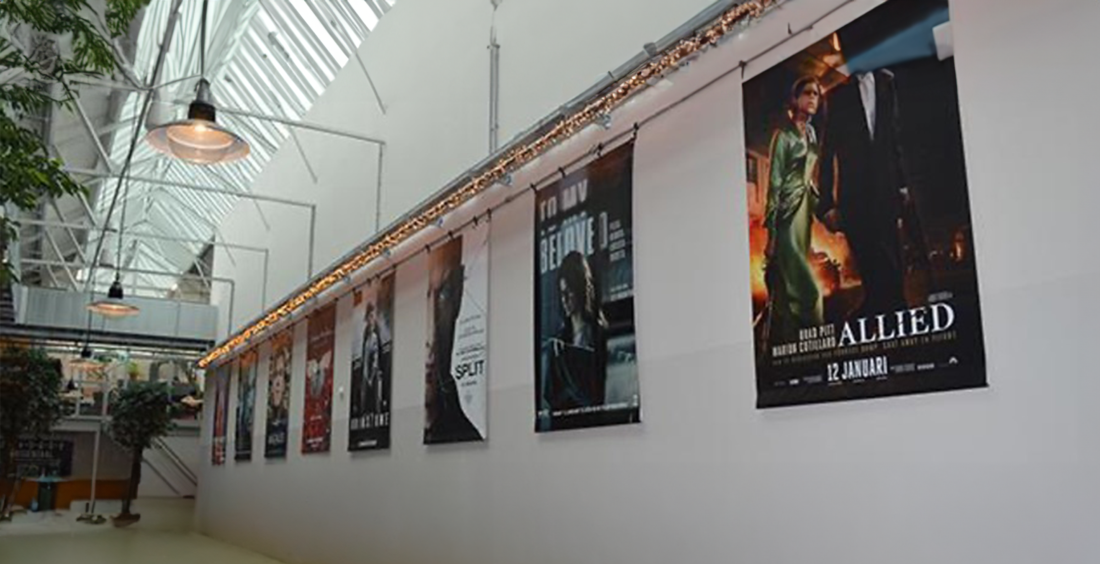 spandoeken bedrukt voor de filmhallen met alle films die ze draaien en die in de gang van de filmhal hangt met veel licht.