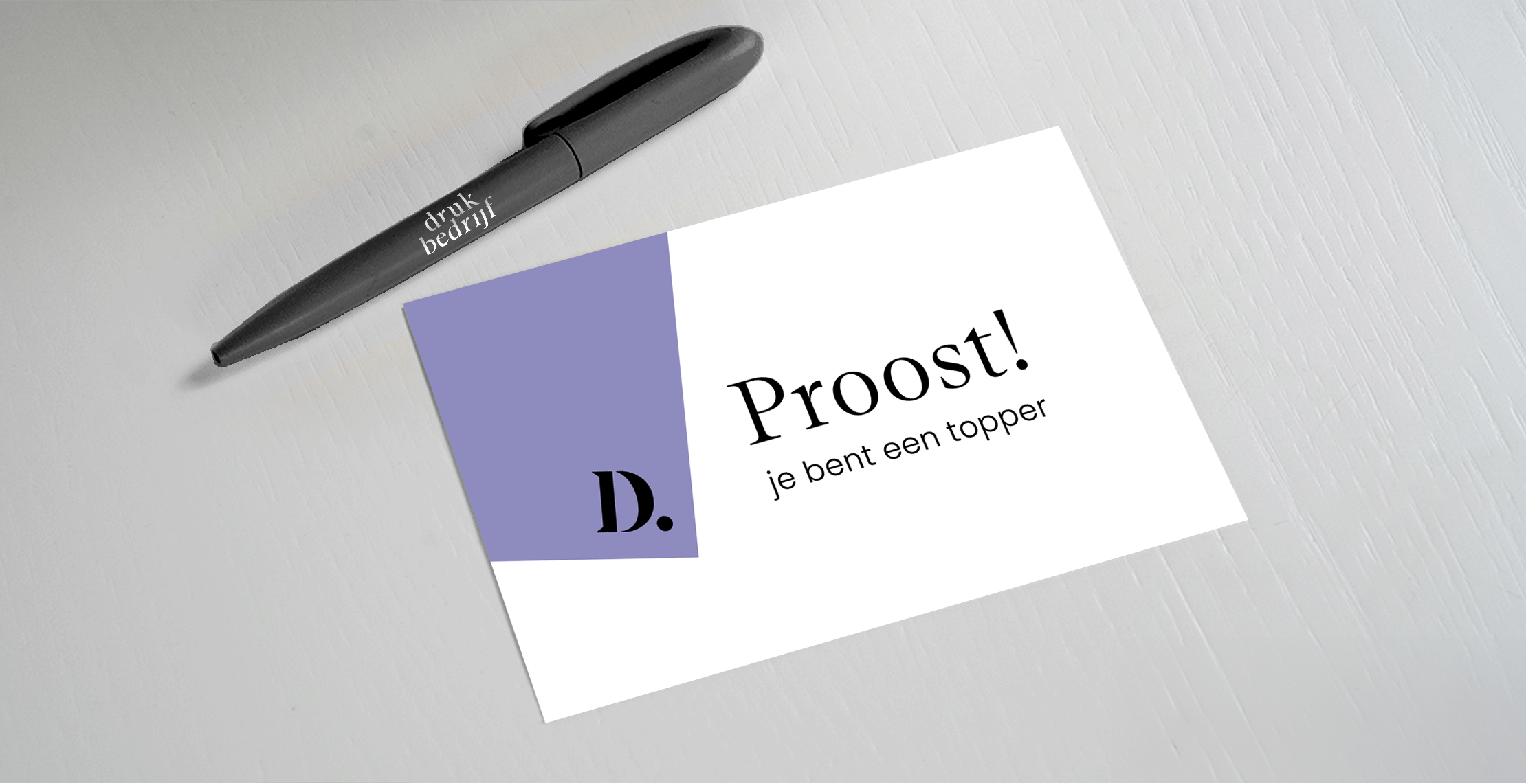 Persoonlijk kaartje bij je relatiegeschenk op witte tafel met zwarte pen bedrukt