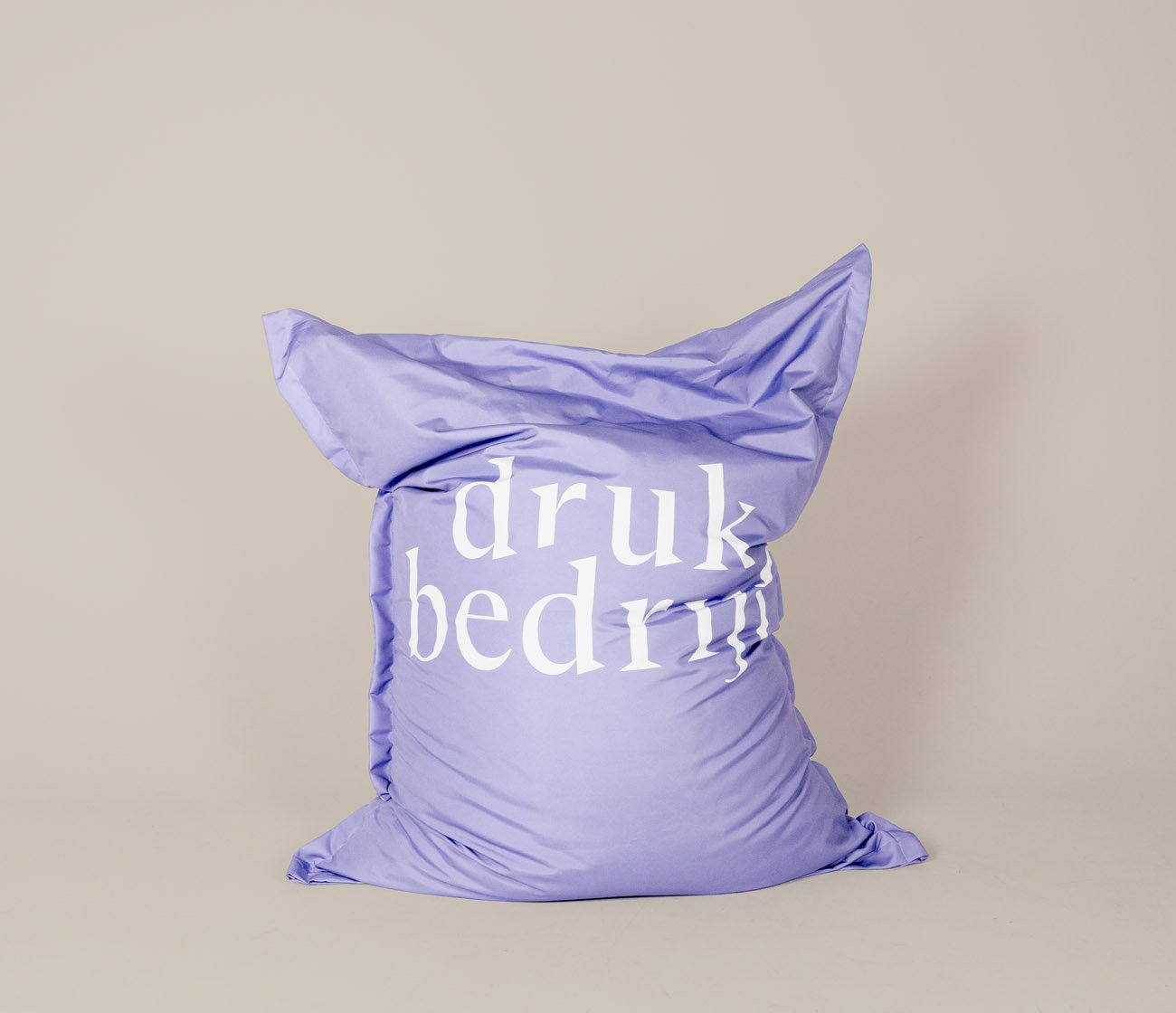 Paarse bedrukte zitzak in een beige omgeving met logo van drukbedrijf. 