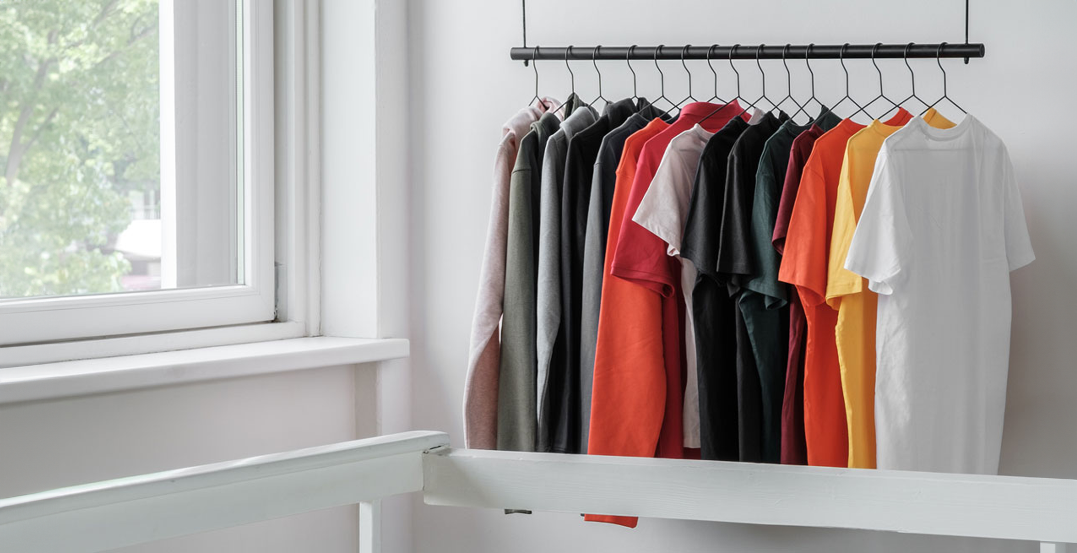 Kleding bedrukken witte shirts op rek in witte ruimte.