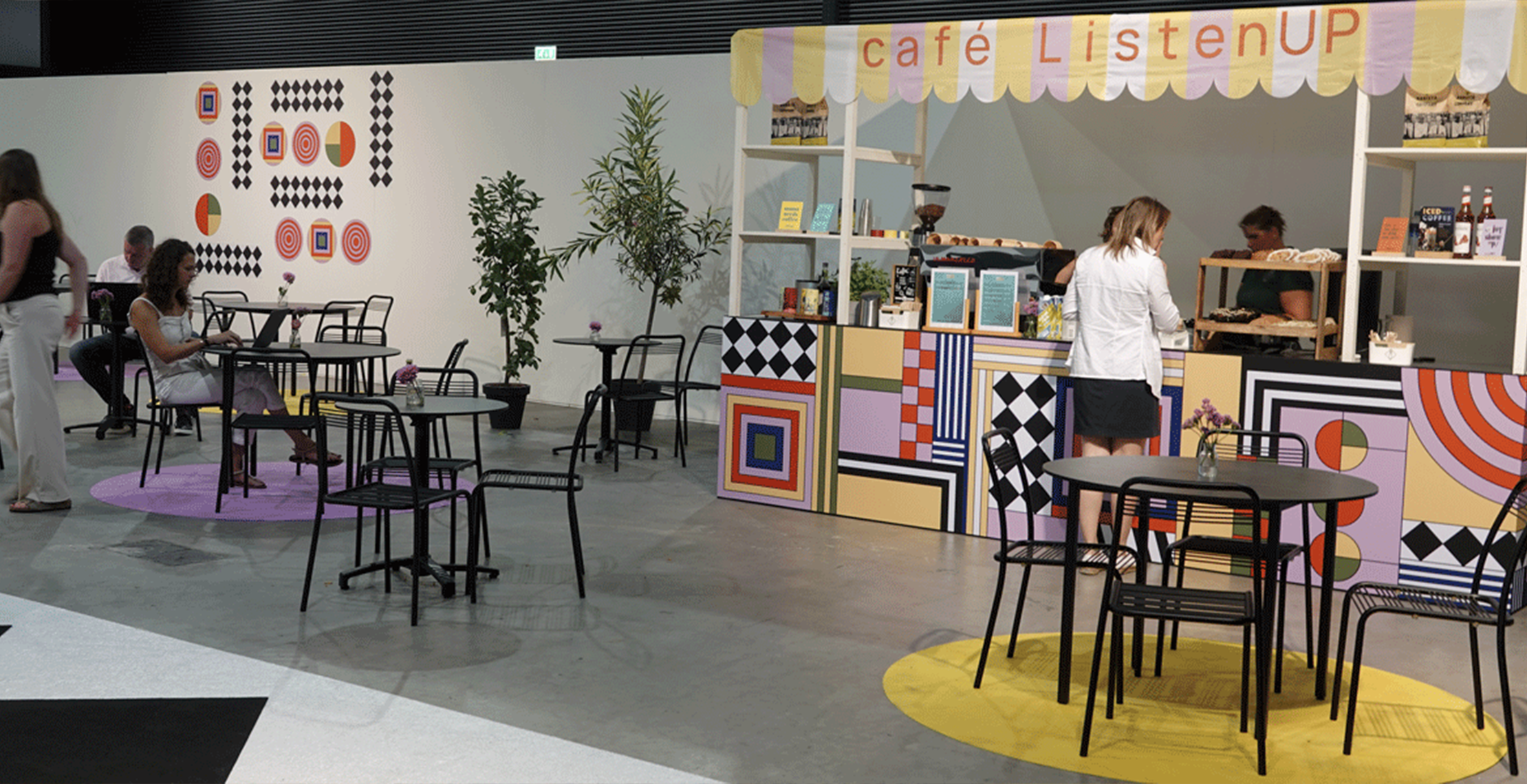 Koffietentje met bedrukte spandoeken op een beurs.