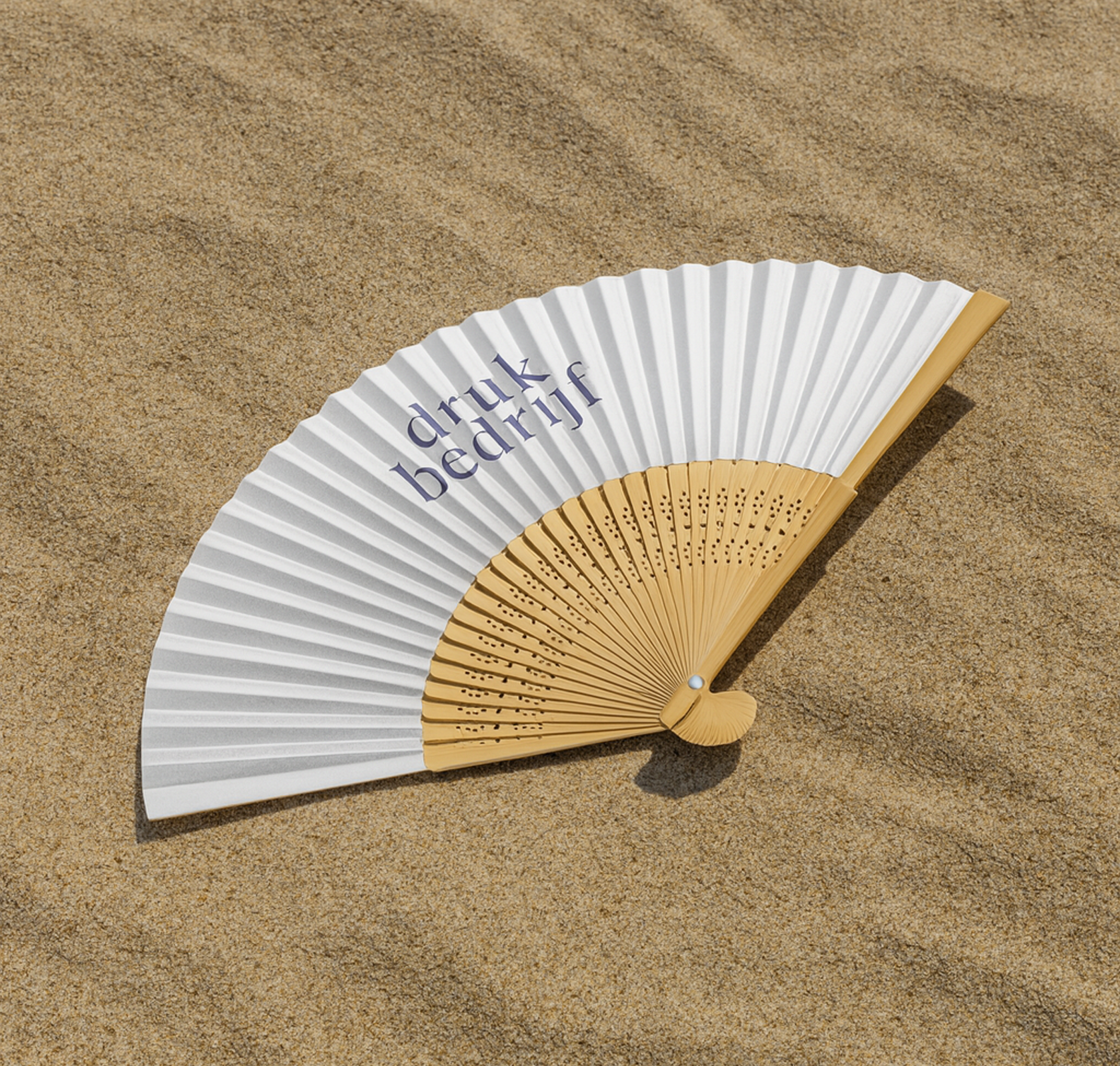 witte waaier bedrukt met logo in het zand
