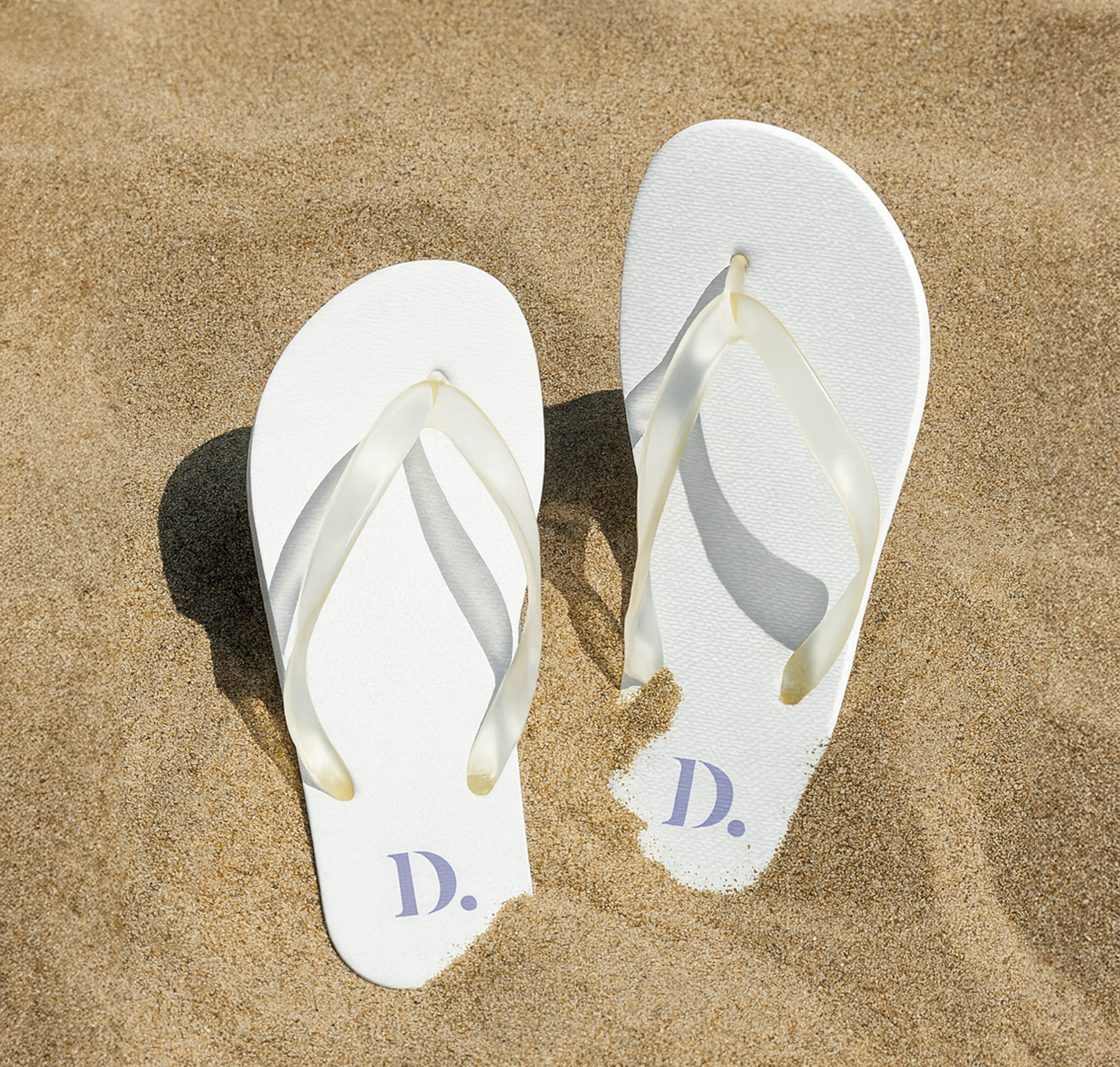 witte bedrukte slippers in het zand