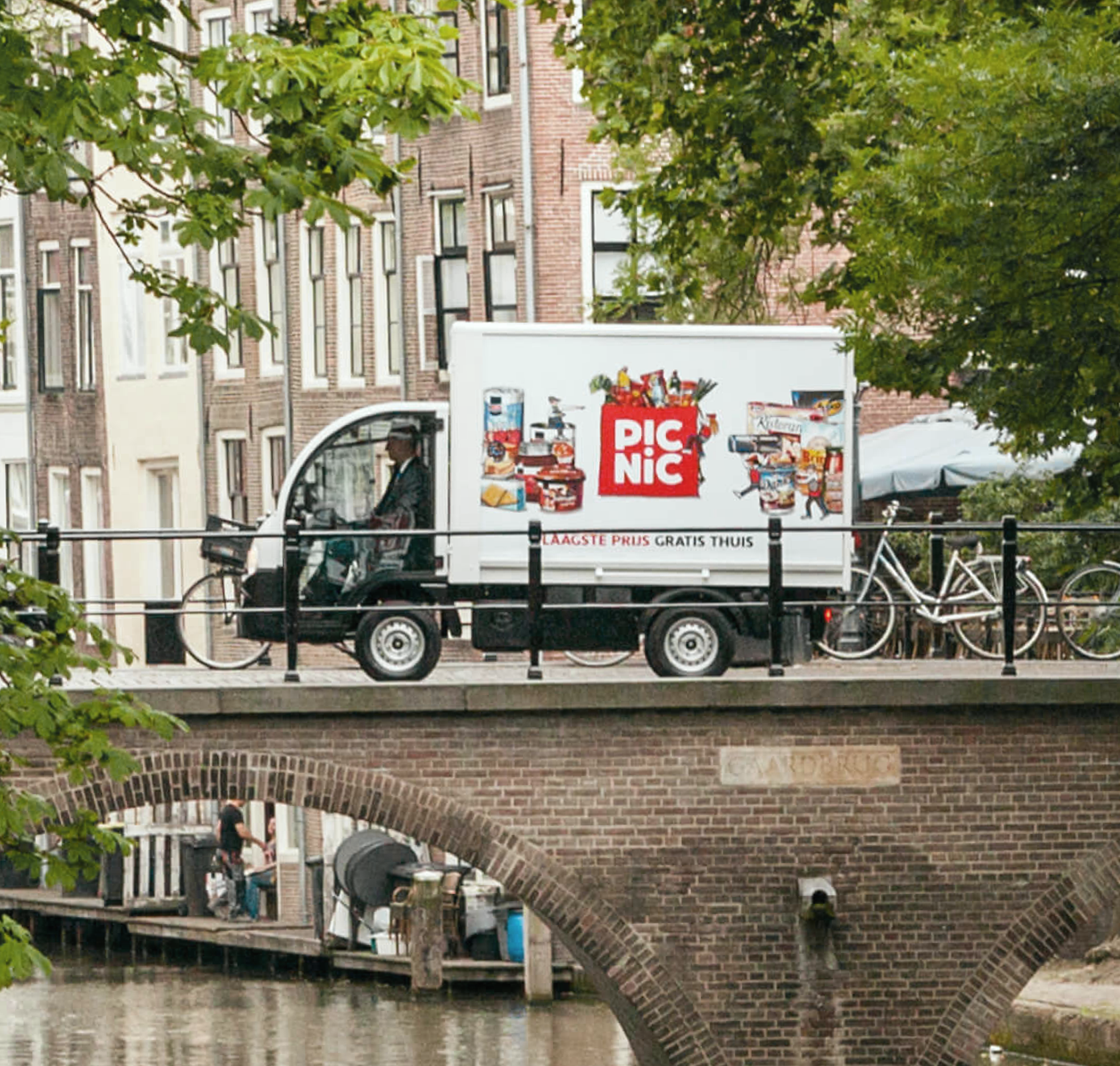 Drukwerk voor Picnic: opvallende wagen rijdend door Amsterdamse grachten met bedrukt drukwerk voor merkherkenning