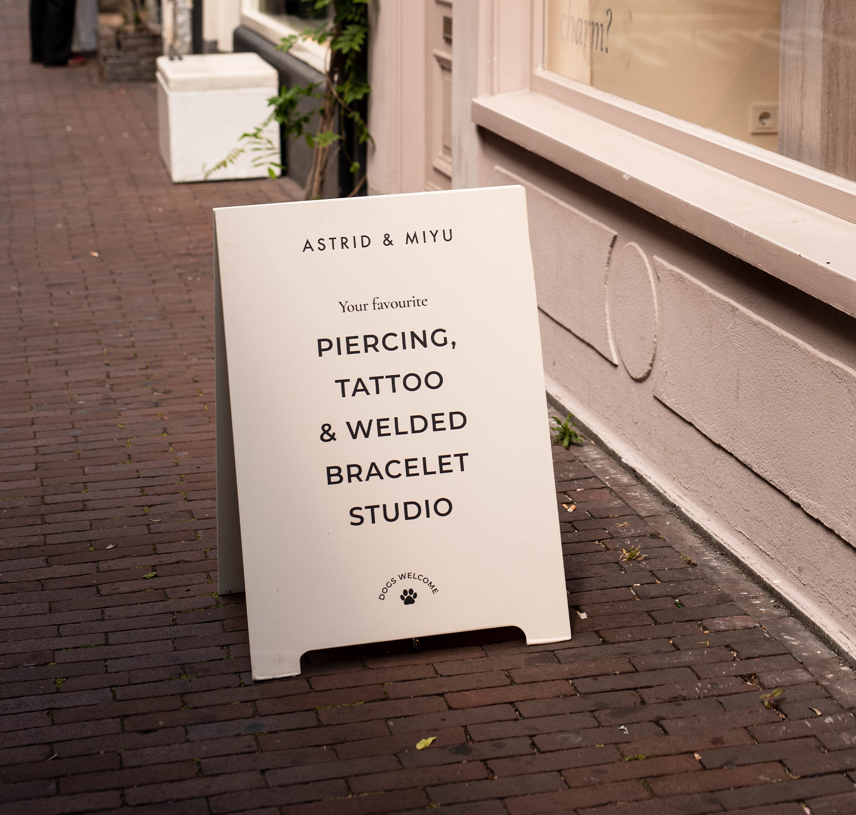 wit stoepbord bedrukt voor astrid en miyu staat buiten in amsterdam op de straat