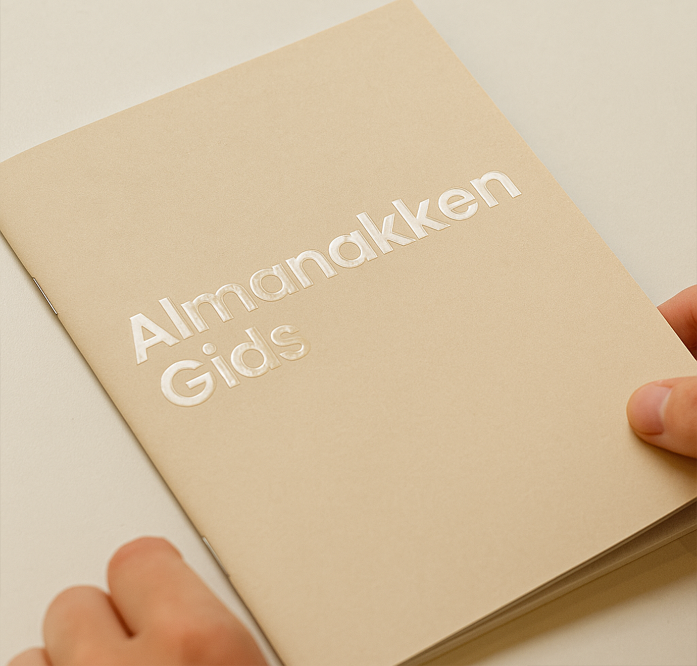 almanakken gids beige bedrukt met spotuv met vingers erbij