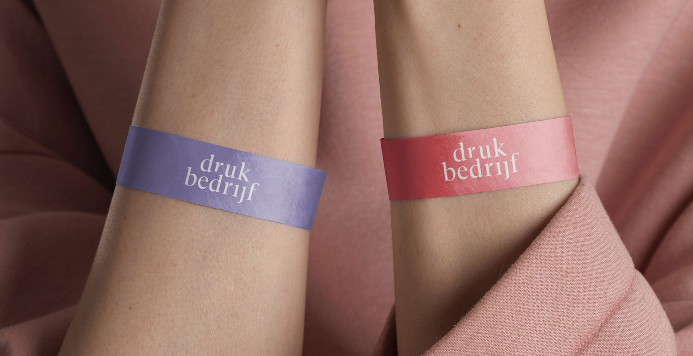 Twee armen met een roze en paars tyvek polsbandje bedrukt met ontwerp.