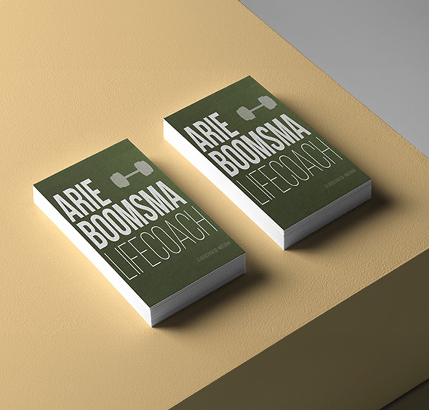 Arie Boomsma visitekaartjes met soft touch en groen ontwerp op gele tafel. 