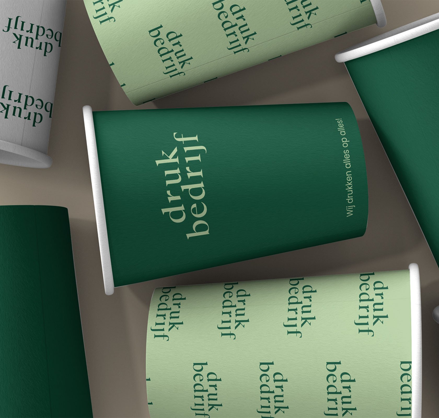 Ecologische bekers liggen naast elkaar in donkergroen en lichtgroen bedrukte bekers.