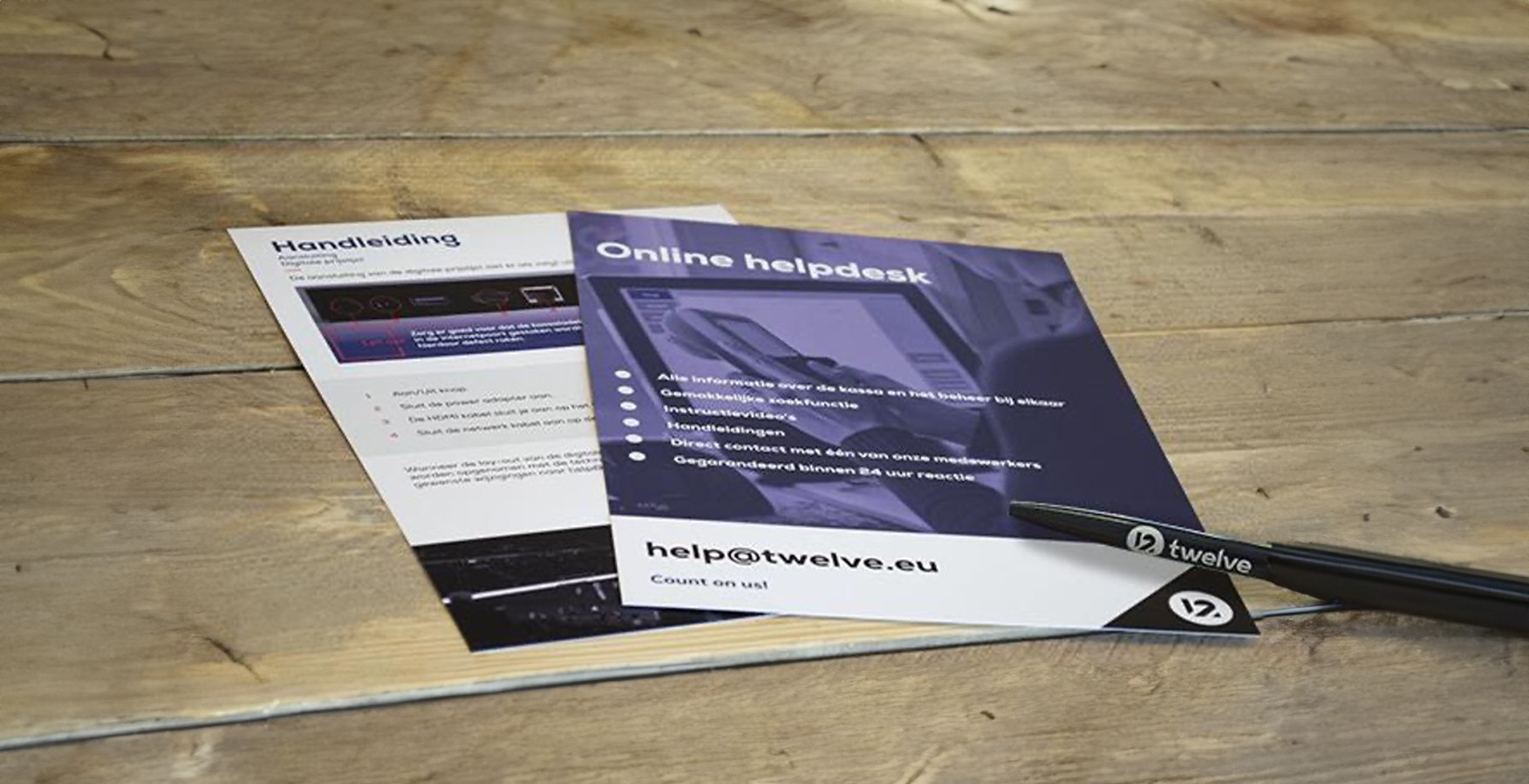 Bedrukte flyer en pen voor twelve klant op houten tafel.