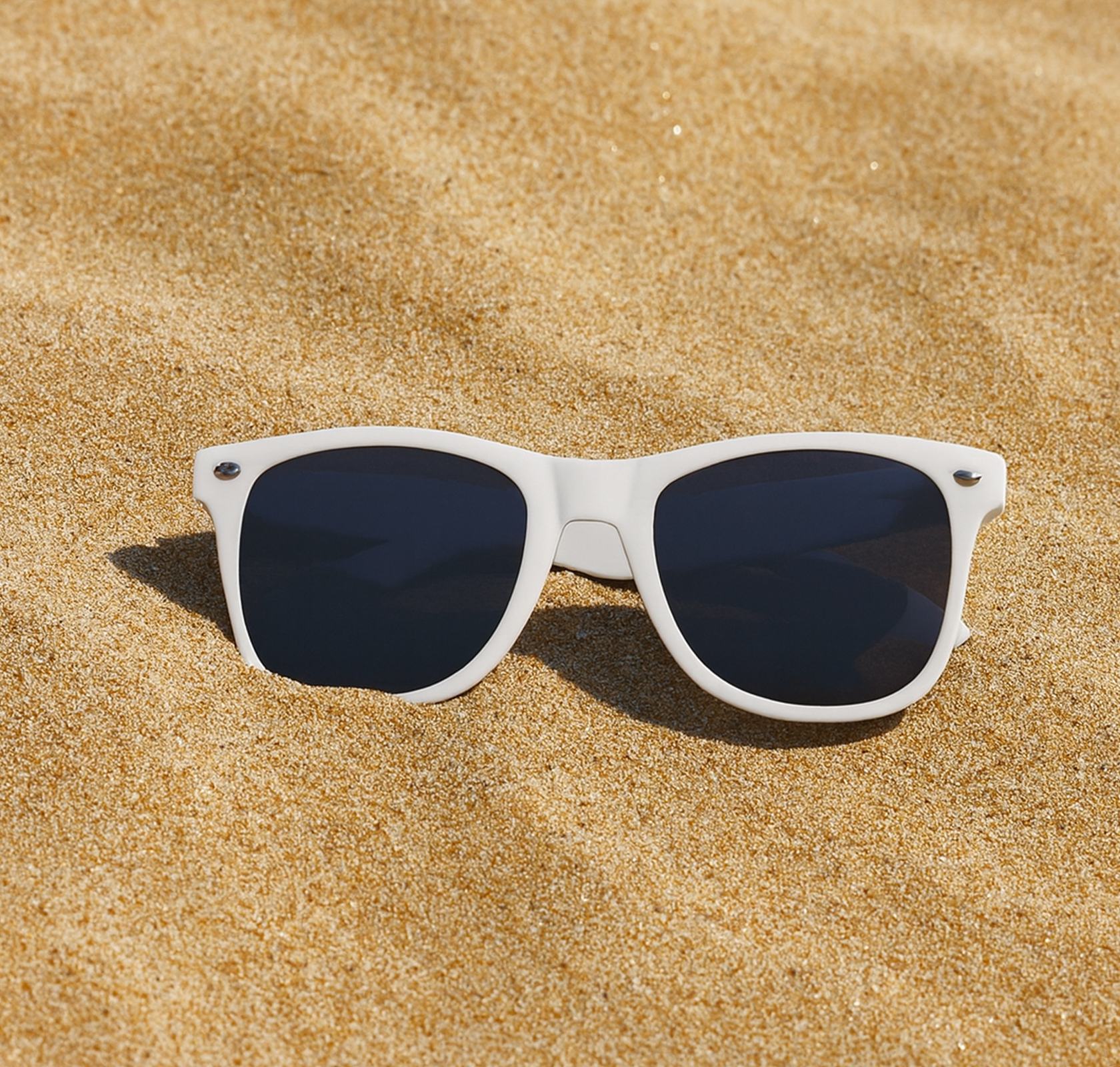 witte zonnebril bedrukt in het zand